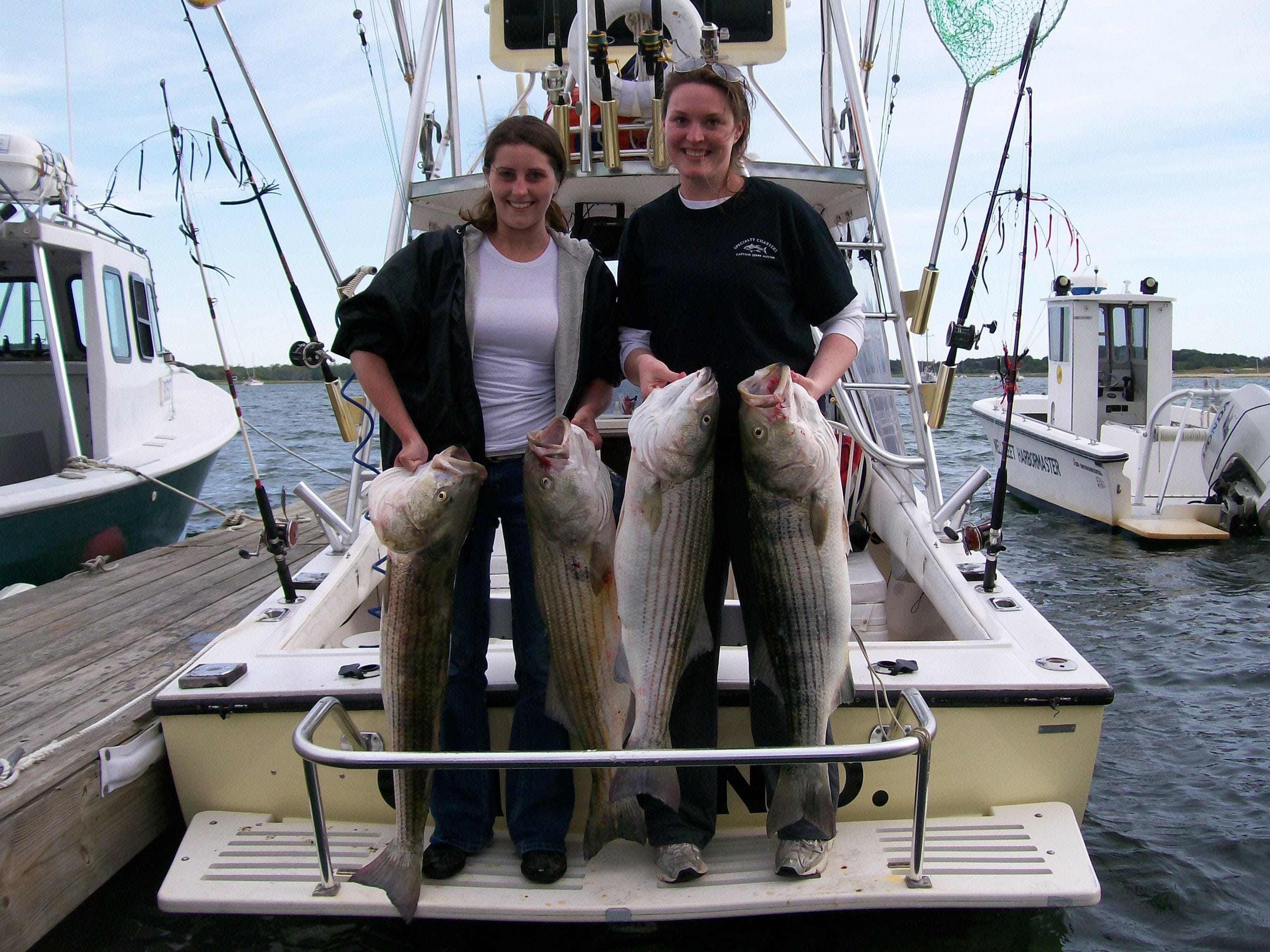 Happy Women Holding Striper Fish with Both Hands